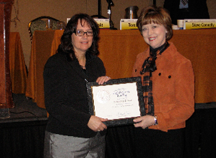 Debbie Dufour (left), Farm Loan Chief in Maine, accepts a certificate from Administrator Teresa Lasseter (right) to commemorate her completion of the Farm Loan Chief Mentoring Program. 